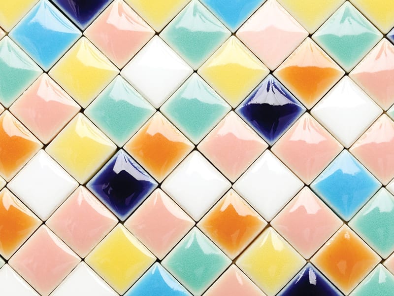  Multi-colored tiles lined up on a black background. 