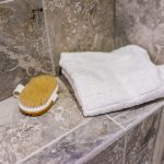 Close up of shower bench with towel and brush